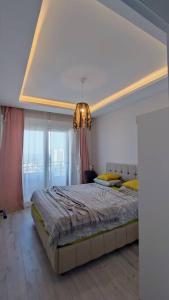 Un dormitorio con una cama grande y una lámpara de araña. en Прекрасный вид на море, en Mezitli
