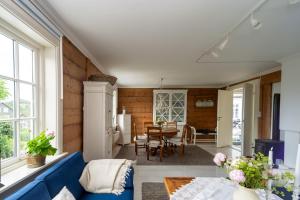 uma sala de estar com um sofá azul e uma mesa em Historisk sjarm - moderne komfort 10min fra Bergen em Bergen