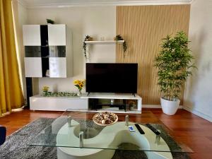 a living room with a tv and a glass table at N3 Apartment in Amadora