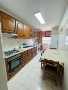 una cocina con armarios de madera y una mesa. en Amorosa Guest House, en Saborido