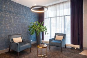 a waiting room with two chairs and a potted plant at Sandman Hotel Montreal - Longueuil in Longueuil