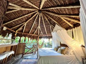 a bedroom with a bed in a straw roof at Jungle Lodge in Abraão