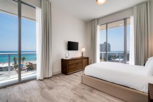 una camera da letto con un letto grande e grandi finestre di Costa Hollywood Beach Resort - An All Suite Hotel a Hollywood