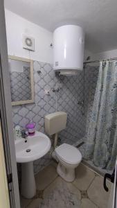 a small bathroom with a toilet and a sink at Welcome Guest House in Shkodër