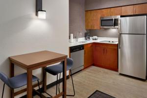 eine kleine Küche mit einem Tisch und einem Kühlschrank in der Unterkunft Residence Inn Asheville Biltmore in Asheville