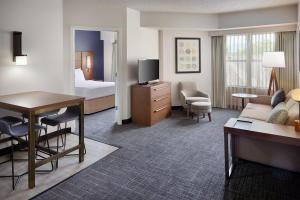 a hotel room with a bed and a living room at Residence Inn Asheville Biltmore in Asheville