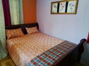 a bed in a bedroom with a picture on the wall at palms in Jerningham Junction