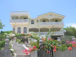 a large yellow house with stairs and flowers at Zamaca' Bed and Breakfast in Micoud