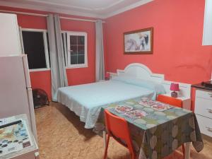 プエルト・デル・ロサリオにあるVivienda Perez Martinの赤いベッドルーム(ベッド1台、テーブル付)