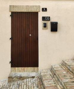 uma porta castanha do lado de um edifício em Dolci Soggiorni em Loreto