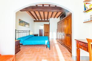 ein Schlafzimmer mit einem blauen Bett und einem Torbogen in der Unterkunft Casa Marlèn in Collazzone