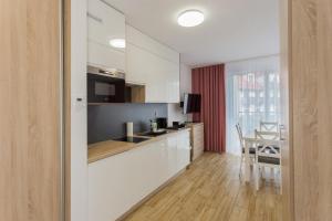 kuchnia z białymi szafkami i jadalnią w obiekcie K2 Apartamenty w mieście Karpacz