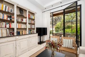 a living room with book shelves and a tv at Villa Elisa in Málaga