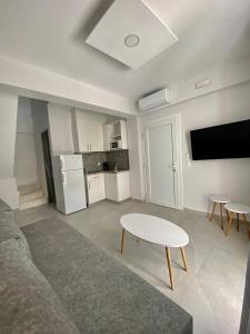 a living room with a couch and a table and a tv at INTERNI LUXURY LIVING in Nikiti
