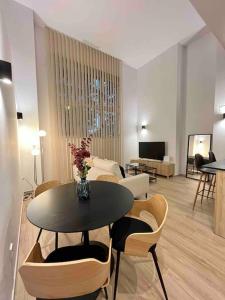 sala de estar con mesa, sillas y sofá en WeRentVLC - Espectacular Loft Duplex 1 hab, en Valencia