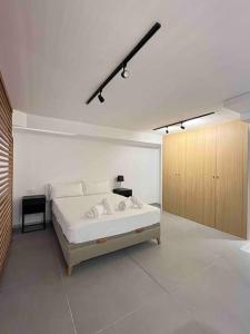 um quarto branco com uma cama grande e um armário de madeira em WeRentVLC - Espectacular Loft Duplex 1 hab em Valência