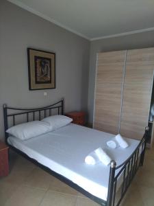 ein Schlafzimmer mit einem Bett mit zwei Handtüchern darauf in der Unterkunft Vasiliki's Apartment in Nea Kallikratia