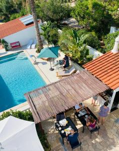 een uitzicht op een zwembad met zitplaatsen bij Palm View Guesthouse, adults only in Luz