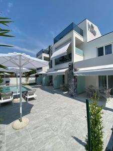 a large building with a patio with an umbrella at INTERNI LUXURY LIVING in Nikiti