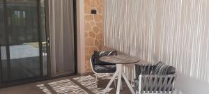 a table and two chairs sitting next to a window at Astrum Luxury Suites in Vourvourou