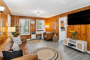 a living room with a couch and a flat screen tv at Twin Peaks Vacation Rental with Hot Tub! in Twin Peaks