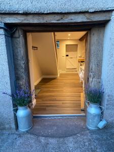 a hallway with two blue vases with flowers in them at The Cottage at Sychnant Farm in Talgarth