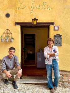 a man and a woman standing outside of a building at LA GIALLA di Via Silvano 12 in Monforte dʼAlba