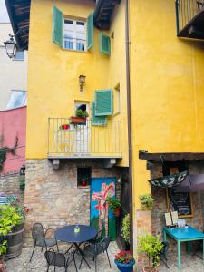 a yellow building with tables and chairs and a balcony at LA GIALLA di Via Silvano 12 in Monforte dʼAlba