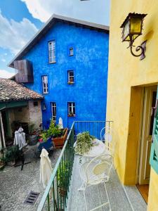 a blue building with a table and chairs on a balcony at LA GIALLA di Via Silvano 12 in Monforte dʼAlba +28 photos