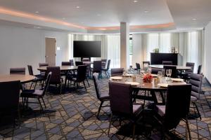 a dining room with tables and chairs and a projection screen at Courtyard Philadelphia Plymouth Meeting in Plymouth Meeting
