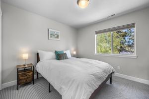 a white bedroom with a bed and a window at Edro Place in Bend