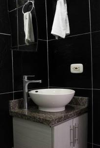 a bathroom with a sink and a black wall at Hermoso Apartamento en el Norte in Montería