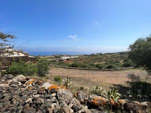 uma vista para o oceano a partir de uma colina com pedras em Dammuso i Pini di Kaddiuggia (CIR19081014C224053) & Dammuso di Mena (CIR 19081014C224052 em Pantelleria