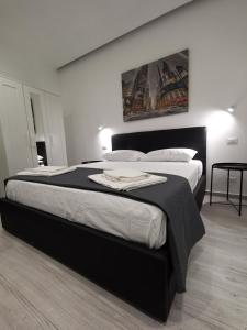 1 dormitorio con 1 cama grande y cabecero negro en Trinity Apartment, en Catania