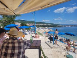 茨里克韋尼察的住宿－Kamena Kuca，坐在海滩上桌子上的人