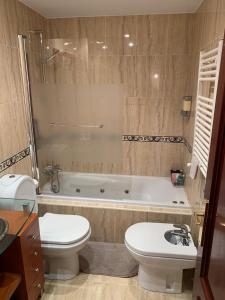 a bathroom with a tub and a toilet and a sink at Maison Villaviciosa Asturias in Villaviciosa
