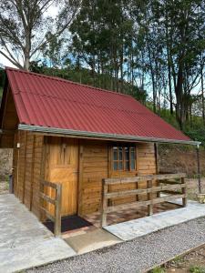 MunhozにあるPousada Pedra da Mata chalés na montanhaの赤い屋根の小さな木造キャビン
