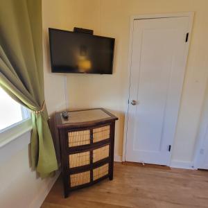 a room with a television on the wall and a door at Kohala Village INN in Hawi