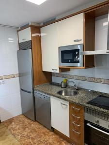 cocina con nevera de acero inoxidable y fregadero en Maison Villaviciosa Asturias, en Villaviciosa