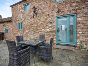 a table and chairs in front of a brick building at The Forge - Uk44517 in North Thoresby