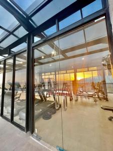 einen Fitnessraum mit Glasfenstern und einen Fitnessraum mit Schaukeln in der Unterkunft Verdela Pollux Meisterstadt Batam apartement in Batam Center