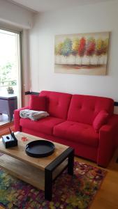 1 sofá rojo en la sala de estar con mesa de centro en L'épopée de l'Avenue - Parking - Avenue de Champagne - Epernay en Épernay