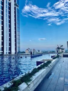 a swimming pool in front of two tall buildings at Verdela Pollux Meisterstadt Batam apartement in Batam Center