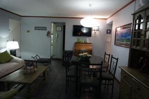 sala de estar con mesa, sillas y sofá en Departamento La Palmera, en Viña del Mar