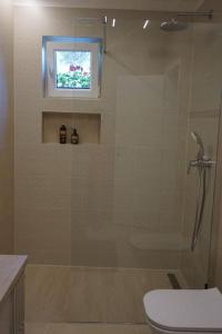 une salle de bain avec douche, toilettes et fenêtre dans l'établissement Apartman 1, à Omišalj 9 autres photos