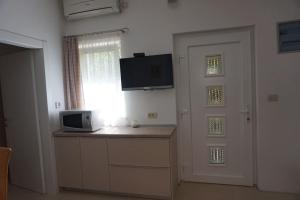 une chambre avec une cuisine équipée d'un four micro-ondes et une porte dans l'établissement Apartman 1, à Omišalj