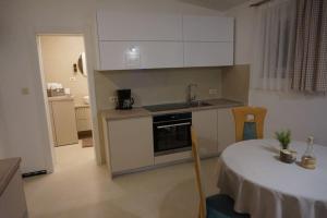 una pequeña cocina con mesa y encimera en Apartman 1 en Omišalj