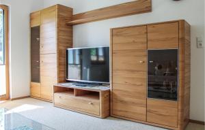 un gran centro de entretenimiento de madera con TV de pantalla plana en Stunning Apartment In Wald Am Arlberg With Wifi, en Wald am Arlberg