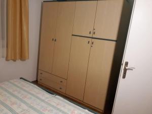 a bedroom with a bed and a closet with cabinets at Apartman 1 in Omišalj