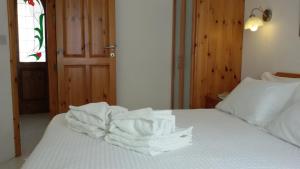 Una cama con toallas blancas apiladas encima. en Villa Xemxija en Xlendi